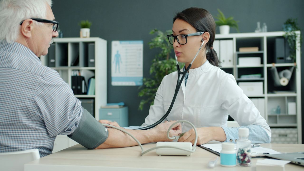 Doctor checking an elderly patient’s blood pressure
