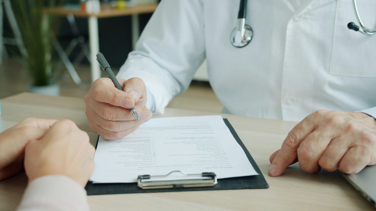 Doctor completing documentation on a clipboard